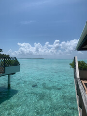 A day in the Maldives, a villa with green shrubs in flower beds over the water near the coast of the Indian Ocean