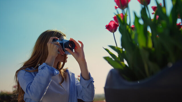 Closeup woman taking tulip photo in sunshine. Unrecognizable girl enjoying hobby
