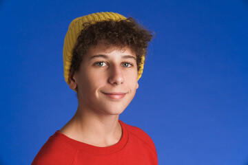 White boy wearing hat smiling and looking at camera