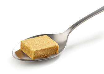 instant chicken broth cube in a spoon