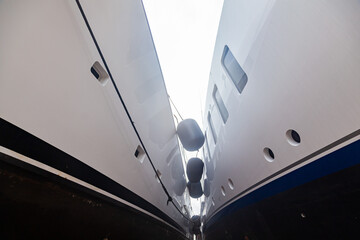 Two luxury motor yachts huddled together on fenders.