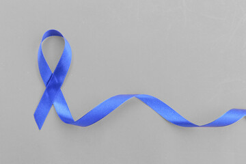 Blue awareness ribbon - symbol for fighting prostate cancer, support the survivors and child abuse awareness. Isolated on white background, copy space, close up, top view, 