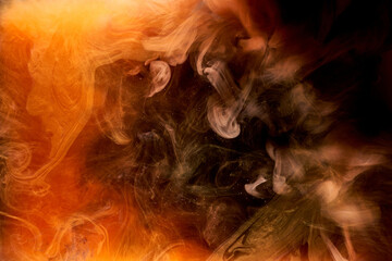 Orange smoke on black ink background, colorful fog, abstract swirling ocean sea, acrylic paint pigment underwater