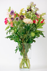 Obraz premium Beautiful bouquet of flowers in a vase. Bouquet of chrysanthemum, alstroemeria, goldenrod, snapdragon, lisianthus and eucalyptus parvifolia. bouquet of flowers on white background. 