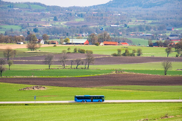 Bus traveling on a country road in a rural landscape