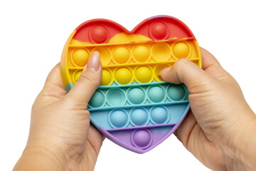 Women's hands play an Anti-stress sensory toy, Rainbow heart on a white background, isolated. New colorful bubbles.