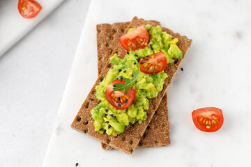 Sandwich with avocado guacamole on light board. Close up