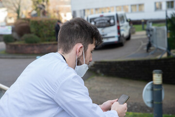 Portrait d'un soignant, personnel médical ou infirmier devant un hôpital portant un masque de...