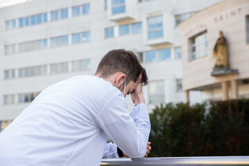 Portrait d'un soignant, personnel médical ou infirmier devant un hôpital portant un masque de...