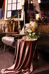 festive Decor. Details. white long candles on gold candlesticks. flower composition with white, yellow, pink flowers and greenery on the black metal table and pink tablecloth. Wedding decorations
