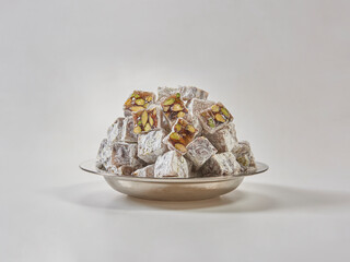 Turkish delight is in the plate, white isolated background.