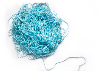 The concept of brainstorming. A tangle of mint, blue cotton threads, needlework yarn on a white background.