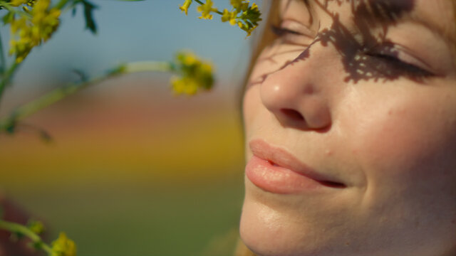 Gentle lady portrait with blooming colza. Woman face smiling to nature outdoors.