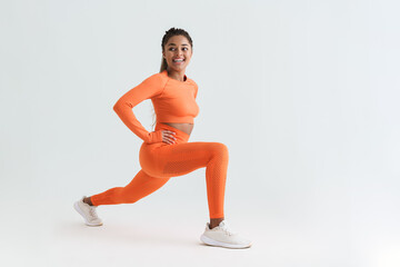 Black young sportswoman doing exercise while working out