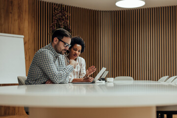 Focused adult partners, checking the yearly budget of their company.
