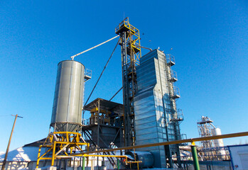 Fototapeta na wymiar Grain plant with equipment on a blue sky background