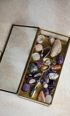 Pendulum and colorful gemstones in a glass box	