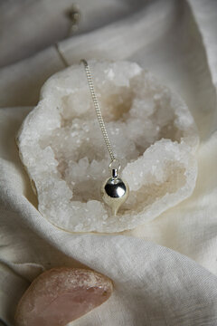 Divination pendulum on a quartz geod