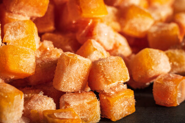 Frozen fresh carrot cube pieces closeup background