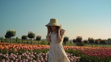 Beautiful lady walking in tulip garden. Woman spending time at flowers field.