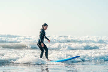 young woman learning to surf the waves alone