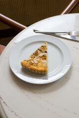 Piece of french quiche pie with cheese and spinach