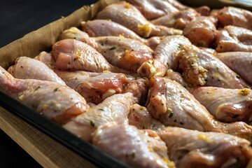 raw chicken drumsticks on baking tray prepared for oven