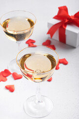 Valentines day background with champagne glasses and gift box with red ribbon. 8 March, Womens Mothers Valentines Day, Birthday. Flat lay, top view, copy space.