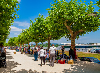 Lovely view of the promenade at the Rhine river in Mainz, Germany. People are strolling and looking...