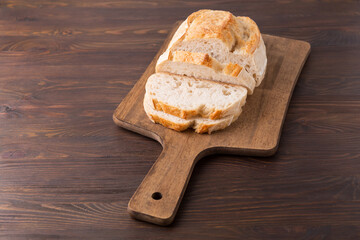 A homemade crusty loaf of bread on dark background