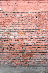 Old red and sometimes plastered and painted brick wall