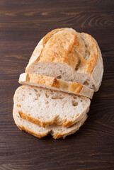 A homemade crusty loaf of bread on dark background