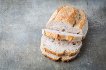 A homemade crusty loaf of bread on dark background