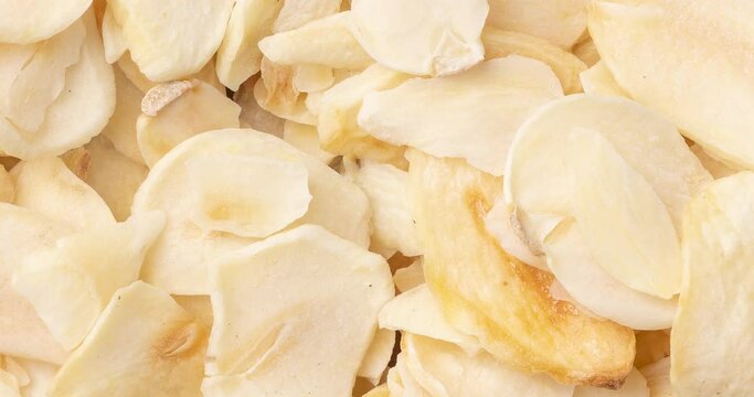 Top view, closeup of dried garlic slices. Food backdrop