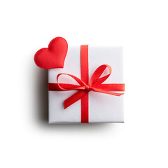Gift box with red ribbon bow and red textile heart isolated on white background. Valentines day and love concept