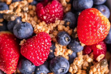 granola with fresh strawberries blueberries and raspberries closeup