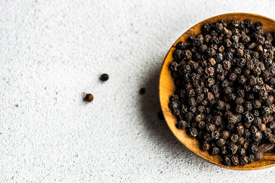 Overhead view of a bowl of black peppercorns
