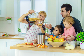 The family is making smoothies in the kitchen. Selective focus.