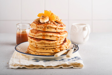 Pancakes. Homemade fluffy pancake with banana, walnut and caramel for breakfast on light concrete background. Delicious pancakes for traditional American breakfast. Selective focus. Mock up.