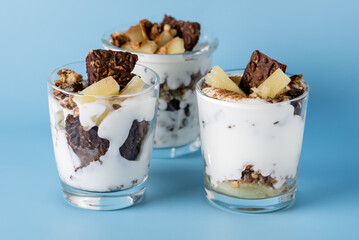 Healthy Dessert of Natural Yogurt Cookies with Oatmeal and Pineapple Served in Glasses Portion Desert in Glass Copy space Blue Packground Horizontal