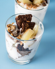 Healthy Dessert of Natural Yogurt Cookies with Oatmeal and Pineapple Served in Glasses Portion Desert in Glass Copy space Blue Packground Vertical