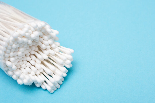 Cotton Buds Stick Out Of The Package On A Blue Background. Place For Text. Copy Space. Layout For Design