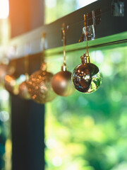 Golden glitter Christmas balls hanging for decorations on background window.Stylish christmas decoration.Christmas and New Year display for celebration,carnival,festival design concept.Selective focus