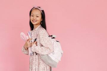 Obraz na płótnie Canvas Asian girl wearing dress smiling while posing with backpack