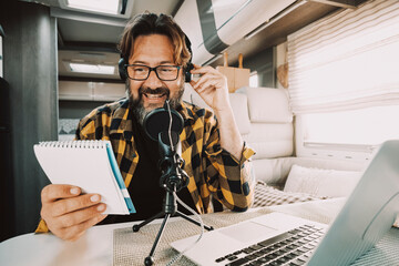 Portrait of handsome adult man speaking to microphone to record online podcast. Modern traveler...