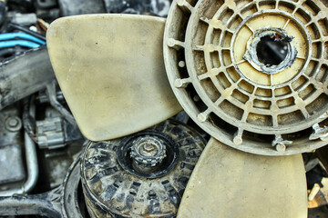 Car engine repair. Urgent repair of a fan malfunction. The old fan of the car broke down, melted in the center.  The theme of cars, auto repair shops, repair.