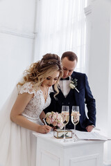 Wedding ceremony. The bride and groom put their signatures. A significant day.