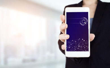 Searching information data on internet networking concept. Hand hold white smartphone with digital hologram search data sign on light blurred background.