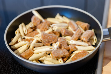 penne pasta with bolognese sauce in a pan