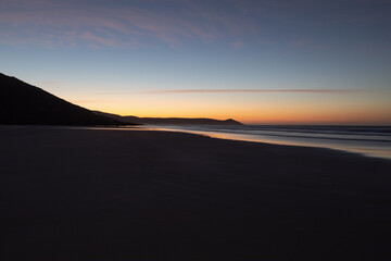 Plakat Tregantle Beach in Whitsand Bay Cornwall at sunrise with reflections in the sand and sea